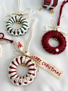 christmas ornaments are arranged on a table with ribbon and tags hanging from the top, along with other holiday ornament decorations