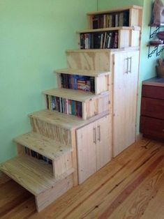 there is a set of stairs made out of plywood and bookshelves in the room