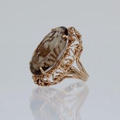 A very fine gold and citrine cocktail ring.   With a large faceted oval citrine prong set in a openwork or filigree setting.  Simply a wonderful Mid-Century ring!  Date:  Mid-20th Century  Overall Condition: It is in overall good, as-pictured, used estate condition with some very fine & light surface scratches and other signs of expected light wear consistent with age.  Fineness: Unmarked for gold fineness. Professionally tests at 14K  Measurements: Height: ca. 29 mm Length: ca. 31 mm Width: ca. Elegant Intaglio Rings For Formal Occasions, Antique Oval Filigree Ring With Intaglio, Classic Oval Filigree Ring With Intaglio, Luxury Oval Filigree Ring For Formal Occasions, Oval Filigree Intaglio Ring Gift, Oval Filigree Ring With Intaglio For Gift, Oval Yellow Gold Filigree Ring With Gemstone, Oval Filigree Intaglio Ring For Wedding, Luxury Oval Engraved Filigree Ring