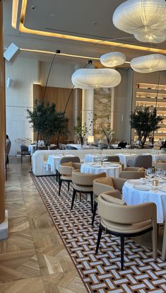 a dining room with tables and chairs covered in white tablecloths