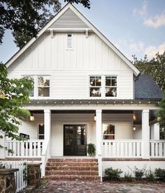 a white house with red brick walkway leading up to the front door