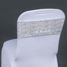 the back of a white chair with silver sequins on it's sash