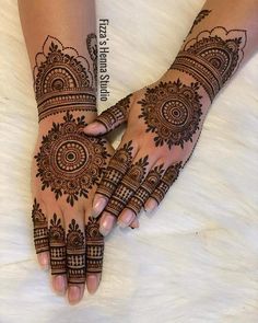 two hands with henna tattoos on them