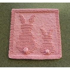 a pink knitted placemat with flowers on it