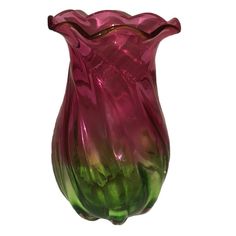 a pink and green vase sitting on top of a table