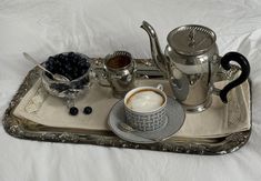 a tray that has some cups and saucers on it with blueberries in the bowl