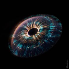 an eyeball is shown in the dark with bright blue and green lights on it