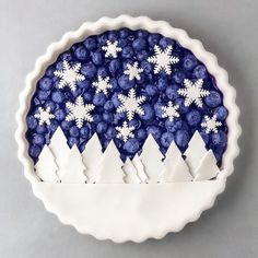 a blue and white bowl with snowflakes in it on a gray surface,