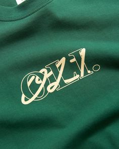 a green t - shirt with white lettering on the front that says fzc