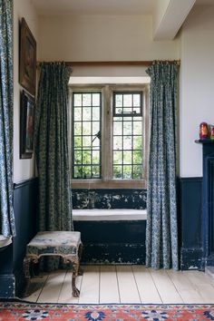 a room with a bench, window and rug on the floor in front of it