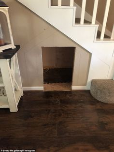 a dog house under the stairs with its door open