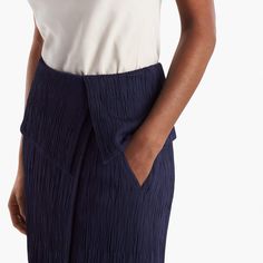 Sizing tip: This skirt runs large. Our stylists recommend ordering one size down. Inspired by classic tuxedo details, this sophisticated skirt features an angular, folded waist detail that creates a peplum-like silhouette. This season, we’ve updated it in a luxurious Italian knit with a pleated texture that allows for shaping and contouring in all the right places. Besom pockets add a little shine, while a secure underlayer keeps you feeling secured and well-covered. Chic Asymmetrical Draped Skirt For Work, Chic Fitted Skirt With Wide Waistband, Chic Draped Skirt For Spring Workwear, Chic Spring Draped Skirt For Workwear, Chic Draped Skirt For Work, Summer Evening Bottoms With Pleated Waist, Asymmetrical Lined Skirt For Work, Lined Asymmetrical Skirt For Work, Summer Fitted Draped Skirt For Workwear