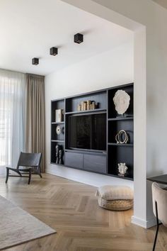 a living room filled with furniture and a flat screen tv on top of a wall