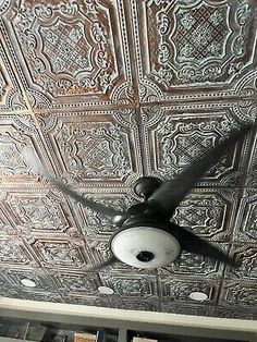 a ceiling fan mounted to the ceiling in a room with metal tining on it