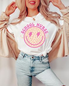 a woman with blonde hair wearing a t - shirt that says school nurse on it