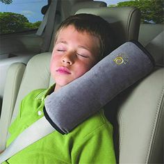 a young boy sleeping in the back seat of a car with an arm pillow on his head