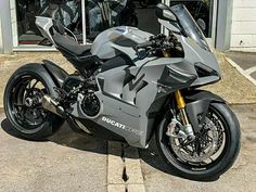 a silver motorcycle parked in front of a building