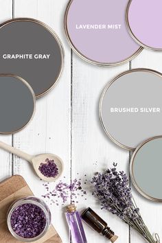 three different shades of gray, lavender and lavender on a white wooden table with spoons