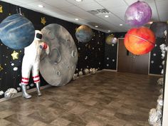 an office decorated with planets, stars and astronaut suits on the wall in front of them