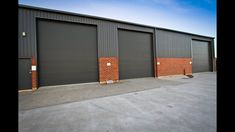 an industrial building with two garage doors and brick walls