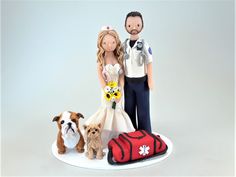 a wedding cake topper with two dogs and a police officer