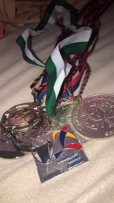 several medals are laying on a bed with ribbons around them and one has a medal in the middle