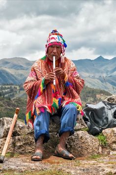 a woman sitting on top of a rock next to a bag and a baseball bat