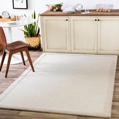 a white rug in the middle of a kitchen