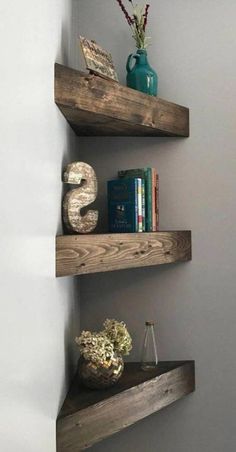 two wooden shelves with books and vases on them in the corner of a room