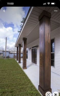 an iphone photo of a porch with columns and grass in the foreground, taken on a sunny day