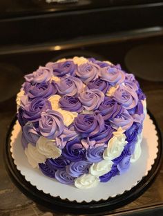 a cake with purple and white frosting roses on it