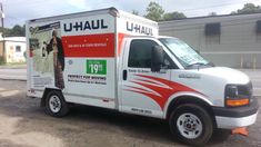 a u - haul moving truck is parked on the side of the road