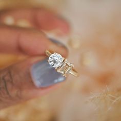 a person holding a diamond ring in their hand