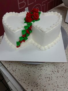 there is a heart shaped cake with two roses on the top and one in the middle