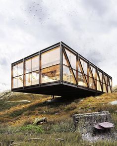 a glass house on top of a hill