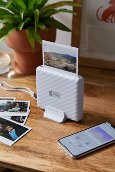 an external hard drive sitting on top of a wooden table next to a cell phone