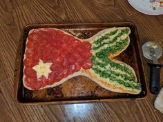 a pizza shaped like an american flag on top of a wooden table next to utensils