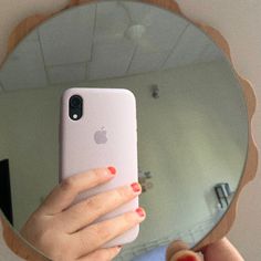 a woman taking a selfie in front of a mirror with her phone up to her face