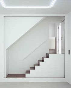 an empty room with white walls and stairs