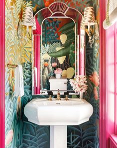 the bathroom is decorated with colorful wallpaper and gold fixtures, including an ornate mirror