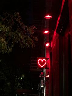 a red light that is on the side of a building with a heart in it