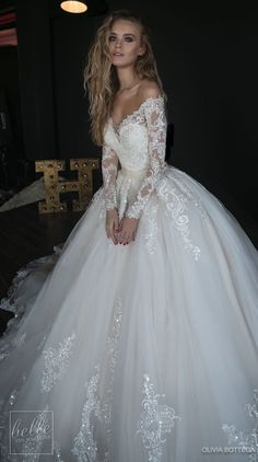 a woman in a white wedding dress posing for the camera with her hands on her hips