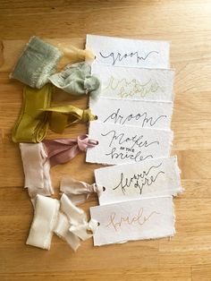 several pieces of cloth with writing on them sitting on top of a wooden table next to each other