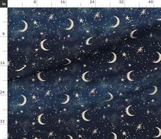 fabric with stars and crescents in the night sky, on a ruler sheet that is measuring