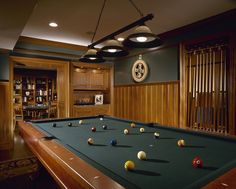 a pool table is in the middle of a room with several billiards on it