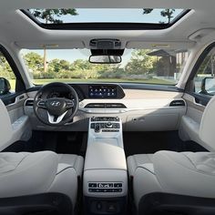 the interior of a car with all white leather seats and dashboards, including center console