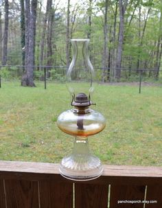 a glass vase sitting on top of a wooden fence