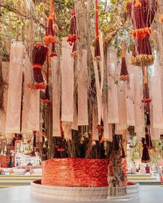 an arrangement of red and orange ribbons hanging from a tree