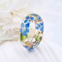 Eco resin ring with  "Forget-me-not"" Materials:Resin, Forget-me-not flower, Forest moss. Gold24K The forget-me-not symbolizes true love and memories that last forever. Custom orders are welcome. Every item comes in a beautiful, individual original box ready for gift giving. Natural VyTvir rings are made with great love for nature If you have any questions please contact me. All rings are resin: https://www.etsy.com/ru/shop/VyTvir?ref=l2-shopheader-name§ion_id=17463694 All rings are made of wood and resin: https://www.etsy.com/ru/shop/VyTvir?section_id=21364732 All rings are made of wood: https://www.etsy.com/ru/shop/VyTvir?section_id=17062884 All rings are made of stainless steel and titanium; https://www.etsy.com/ru/shop/VyTvir?section_id=16906451  #Resin, forget-me-not flower, forest mo Nature-inspired Gift Rings, Round Jewelry With Pressed Flowers For Weddings, Round Pressed Flower Jewelry For Wedding, Handmade Flower Promise Ring, Handmade Promise Flower Ring, Blue Nature-inspired Jewelry For Wedding, Handmade Flower Ring For Promise, Gold Rings With Pressed Flowers For Wedding, Nature-inspired Blue Jewelry For Wedding