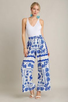 Royal blue and ivory floral print textured wide leg pants Get inspired this season with these stunning ivory and royal blue floral print pants! Featuring a textured fabric with wide legs and an elastic waistband with drawstring. Feel trendy and fashionable at all of your upcoming events! Perfect dressed up with heels and a bodysuit, or worn casually with sandals and a tank top. Shop the look: white eyelet top True to size fit; wide relaxed leg Model is 5'9" wearing a small Fabric doesn't contain Spring Blue Printed Wide Leg Pants, Chic White Floral Print Wide Leg Pants, Printed Blue Wide Leg Pants For Spring, Blue Printed Wide Leg Pants For Spring, Blue Floral Print Pants For Vacation, Summer Printed Blue Wide Leg Pants, Blue Floral Print Wide Leg Pants For Summer, White Eyelet Top, Leg Model